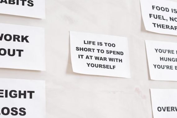 Motivational quotes on white paper promoting healthy habits and lifestyle changes.